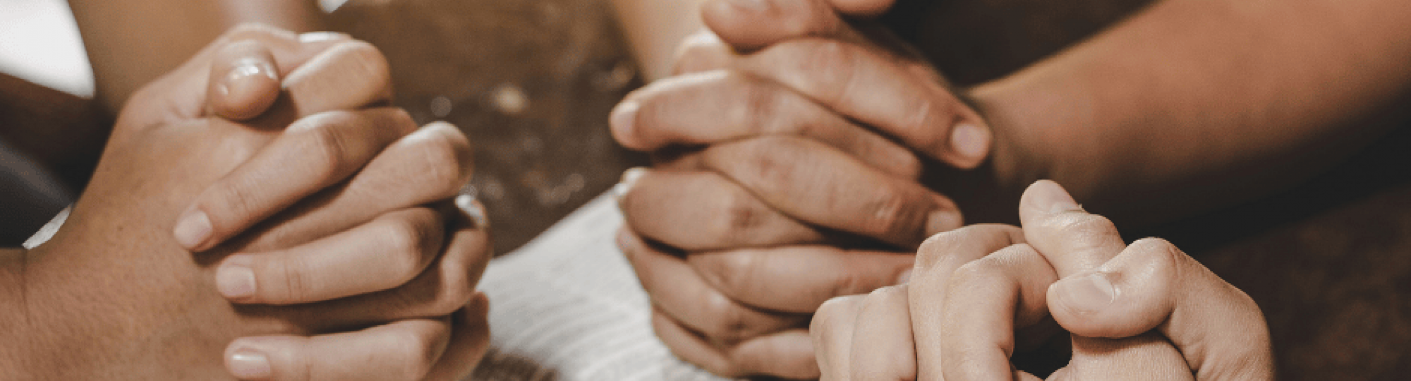 Friends praying over a Bible