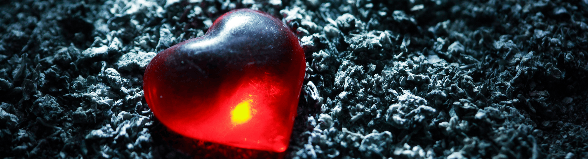 Red heart sitting on ashes